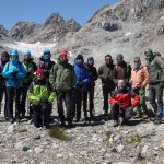 I partecipanti alla escursione guidata di inaugurazione del percorso effettuata il 6 agosto 2023, presso la Stazione 5. Alle loro spalle, la palina nivometrica di colore nero e giallo della stazione meteo (teleosservata tramite webcam: https://www2.n